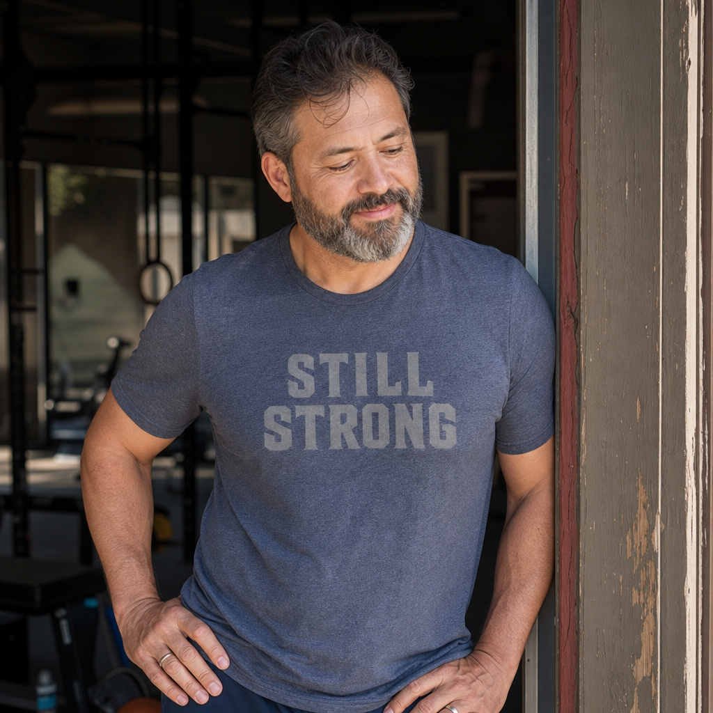Stacked Logo Tee — Heather Blue worn by a strong, weathered man in a real-life setting